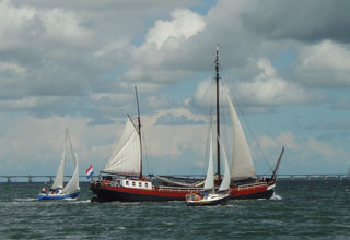 A dutch sailing barge finds a path between two yachts on the Oosterschelde