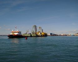 Tugboat and its loaded barge clearing Ramsgate outer harbour